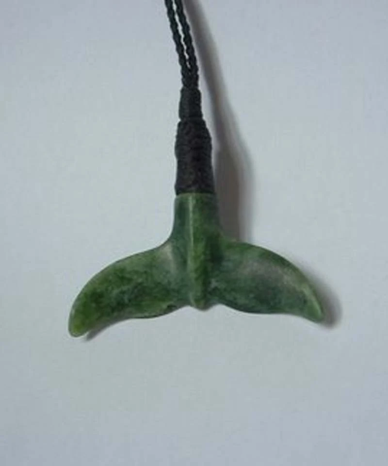 Hand carved pounamu whale tail pendant on a braided black cord, by A Touch of Stone in Hawke's Bay