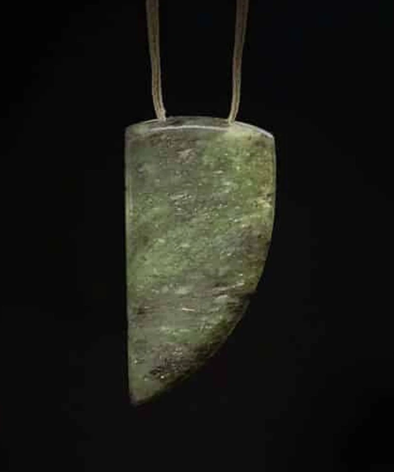 Adze-shaped pounamu pendant hung from a two-point tan cord, hand carved by Campbell Carving in Christchurch