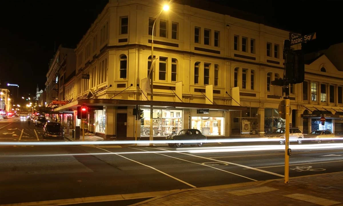 Heritage corner building on Castle Street by Anzac Square in central Dunedin at night, home of Koru NZ Art