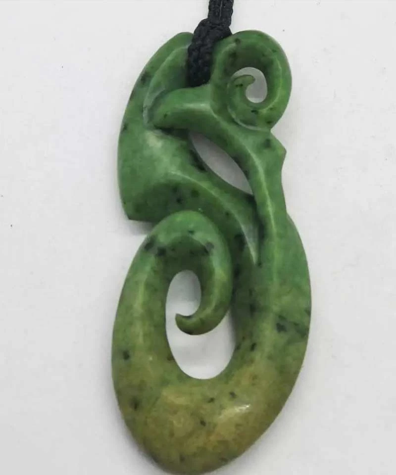 Green pounamu pendant carved in a flowing koru design on a black cord, from Koru NZ Art in Dunedin